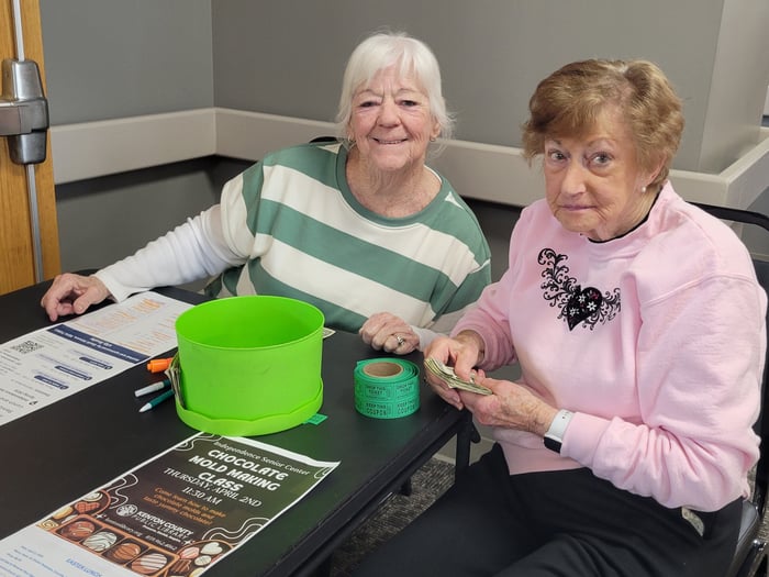 Two attendees at the event look and smile toward the camera.